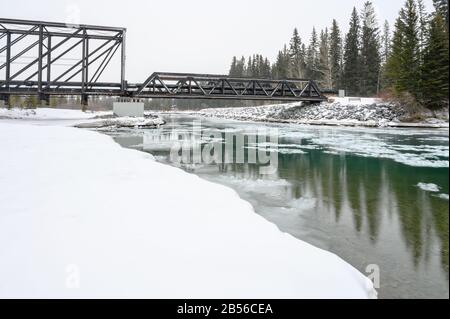 Giornata di neve al ponte motore pedonale che attraversa il fiume Bow a Canmore, Alberta, Canada Foto Stock