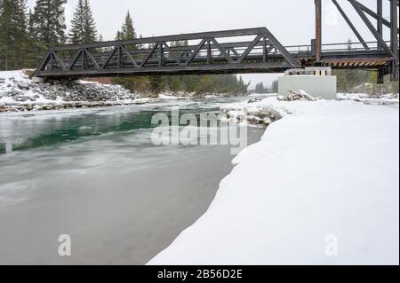 Giornata di neve al ponte motore pedonale che attraversa il fiume Bow a Canmore, Alberta, Canada Foto Stock