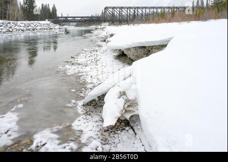 Giornata di neve al ponte motore pedonale che attraversa il fiume Bow a Canmore, Alberta, Canada Foto Stock