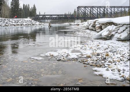 Giornata di neve al ponte motore pedonale che attraversa il fiume Bow a Canmore, Alberta, Canada Foto Stock