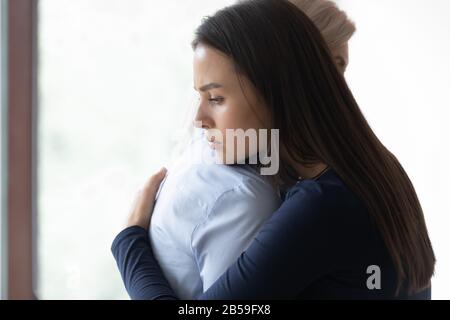 Figlia adulta sconvolta e madre matura abbraccio Foto Stock