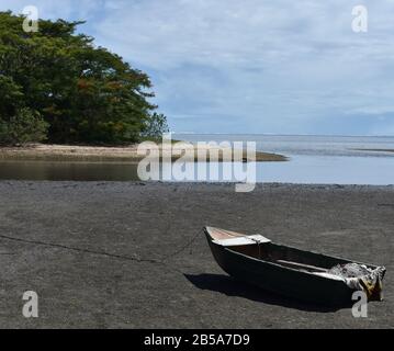 Una vecchia barca poggia sulle distese di marea vicino all'oceano vicino Sigatoka, Fiji Foto Stock