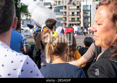 Sint Niklaas, Belgio, 8 settembre 2019, ragazza con capelli e fiori in rilievo che guardano la sfilata Foto Stock