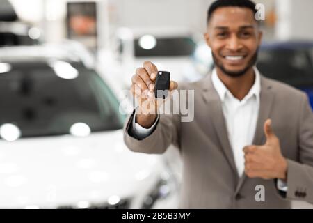 Manager Irriconoscibile Che Mostra Le Thumbs-Up Di Key Gesturing In Store, Profondità Poco Profonda Foto Stock
