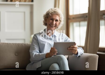 Ritratto di donna matura sorridente con un tablet moderno Foto Stock