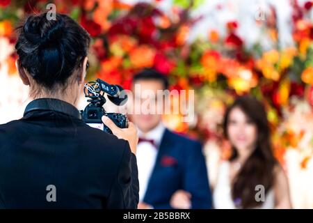 Videografo femmina nella parte posteriore sono shooing e registrazione video in caso di matrimonio. Foto Stock