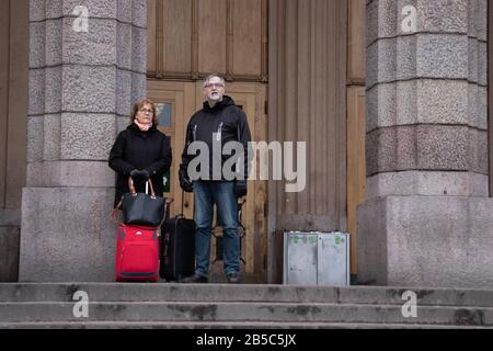 Helsinki, Finlandia - 3 marzo 2020: Turisti che si trovano vicino all'ingresso della stazione Rautatieasema Jarnvags, Editoriale Illustrativa Foto Stock