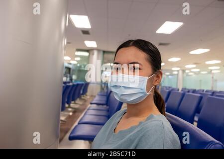 La ragazza asiatica usa una maschera di protezione per il coronavirus o covid 19 in aeroporto Foto Stock