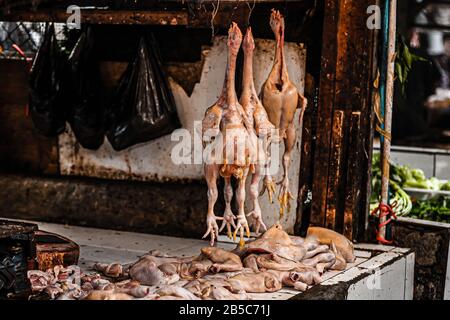 Impiccagione di uccelli macellati in vendita in un tradizionale mercato indonesiano, Lembang, Giava Occidentale, Indonesia Foto Stock