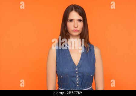 Infelice donna bruna in denim vestito guardando la fotocamera con depressa toglomia viso espressione, sensazione di malinconia dismal, preoccupato per i problemi. Indo Foto Stock