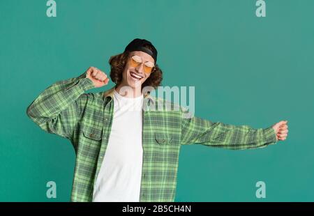 Giovane uomo allegro in abiti casual su sfondo turchese Foto Stock