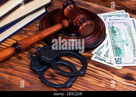 Manette e un gavel in legno di fronte alle cartelle di manila Foto Stock