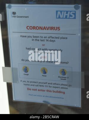 Questo è un avviso su Coronavirus nella finestra di un GP Surgery a Milton Keynes. Foto Stock