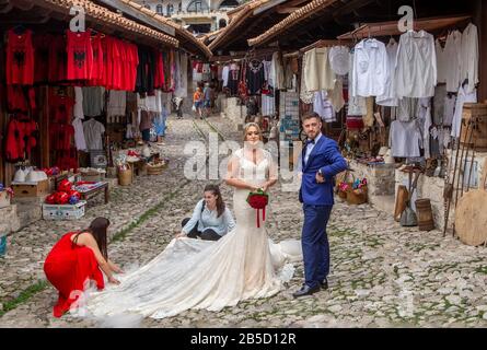 Coppia di nozze prepararsi per la fotografia sulla strada del mercato tradizionale delle pulci di Kruja.Kruja è la città natale di Skanderbeg, l'eroe dell'Albania Foto Stock