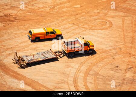 Veicoli da costruzione e tracce di auto sul lato del suolo su argilla da polvere con vista della sabbia dall'alto Foto Stock