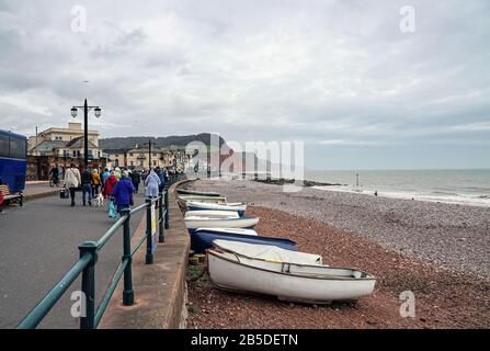 I Daytrippers sono lasciati sul lungomare di Sidmouth per una visita fuori stagione. In lontananza la collina di Seaton e Jurassic Coast è in vista Foto Stock