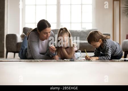 Giovane baby sitter nanny disegno immagine con bambini piccoli. Foto Stock