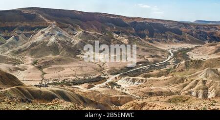 panorama del letto di ruscello di nahal zin, la salita divshon e la strada per ein avdat nel negev in israele con un gruppo lontano di escursionisti nella parte anteriore sinistra Foto Stock