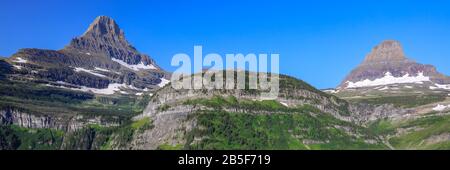 Panorama del paesaggio alpino del Monte Reynolds e del Monte Clements lungo il Logan Pass e il lussureggiante paesaggio verde del Parco Nazionale Glaicer Foto Stock