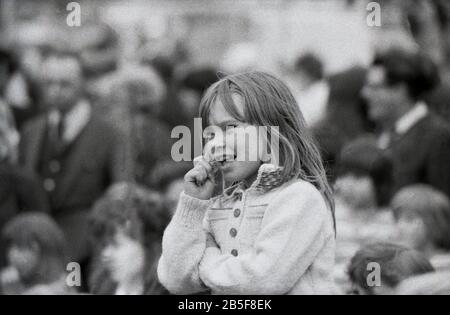 Anni '1970, storica, una giovane ragazza che guarda uno spettacolo Punch & Judy, Inghilterra, Regno Unito. Foto Stock