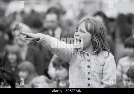 Anni '1970, storico, 'dietro di te, dietro di te'....una giovane ragazza che si fa animare o eccitata guardando uno spettacolo Punch & Judy, Inghilterra, Regno Unito. Foto Stock