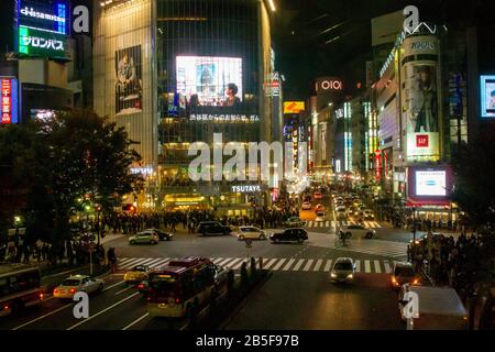 Fotografia notturna di un coronamento di pedoni che attraversa un incrocio a quattro vie zebra al passaggio Shibuya nel centro di Tokyo, Giappone Foto Stock