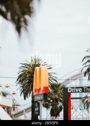 Un cartello McDonalds circondato da palme in Australia Foto Stock