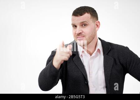 uomo d'affari che punta il suo dito su sfondo grigio con spazio copia Foto Stock
