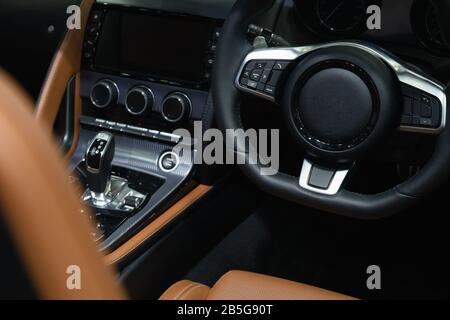 Vista interna Di una moderna vettura sportiva di lusso con salone in pelle, volante con funzione di controllo auto. Foto Stock