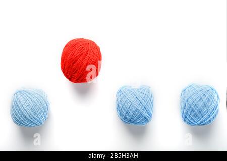 Una sfera rossa unica salta da una fila di sfere di lana identiche. Concetto astratto di leadership, Essere diverso. Lavoro di squadra in azienda e prerequisiti per Foto Stock