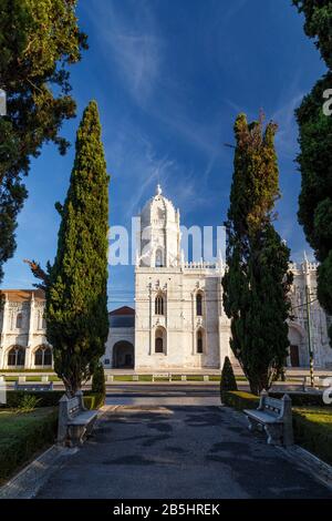 Vista su un parco e lo storico Mosteiro dos Jeronimos (Monastero di Jeronimos) a Belem, Lisbona, Portogallo, in una mattinata di sole. Foto Stock