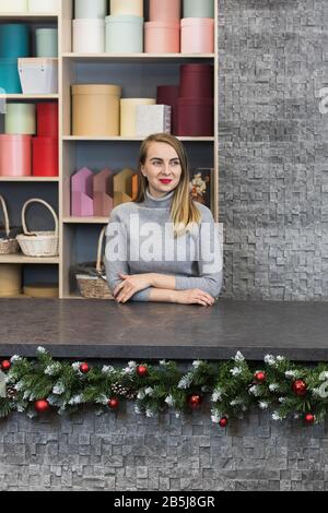 Donna fiorista si trova alla reception in un negozio di fiori. Rappresentante delle piccole imprese. Foto Stock