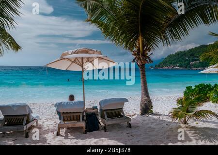 Piscina di lusso in resort tropicale, vacanze rilassanti nelle isole Seychelles. La Digue, giovane uomo al tramonto da swimpool Foto Stock