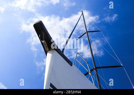 Prua di uno yacht a vela bianco contro il cielo blu, generoso spazio di copia, fuoco selezionato. Vista dal basso. Foto Stock
