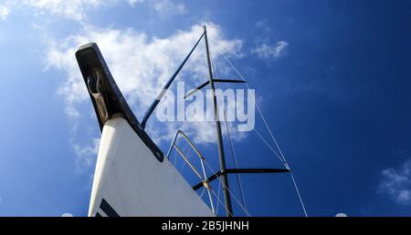 Prua di uno yacht a vela bianco contro il cielo blu, generoso spazio di copia, fuoco selezionato. Vista dal basso. Foto Stock