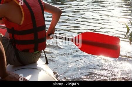 Rafting team , estate sport estremi d'acqua. Gruppo di persone in una barca di rafting, bella scarica di adrenalina lungo il fiume. Vista posteriore. POV Foto Stock