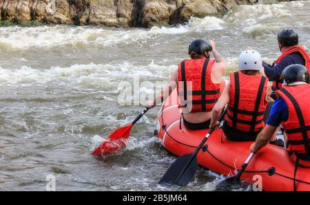 Rafting team , estate sport estremi d'acqua. Gruppo di persone in una barca di rafting, bella scarica di adrenalina lungo il fiume. Vista posteriore. POV Foto Stock