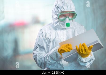 Epidemiologo femminile in abbigliamento protettivo leggere il rapporto di ricerca in quarantena virus, medico professionale lavoro Foto Stock