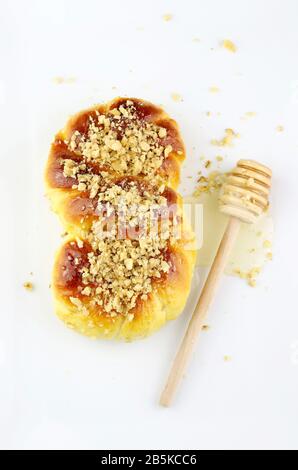 Concetto di cucina rumena. Mucenici fatti in casa, dolci tradizionali cosparsi di miele e noci tritate isolati su sfondo bianco. Foto Stock