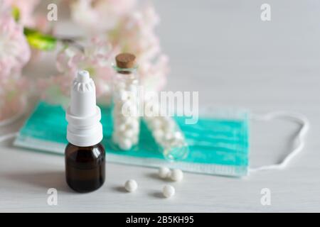 Concetto stagionale di allergia primaverile. Globuli omeopatici e gocce per la cura delle allergie. Foto Stock