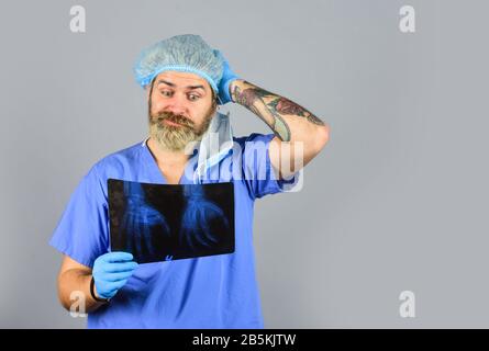 controllo infermiere pellicola radiologica in ospedale. problemi di salute. Operazione di chirurgia e concetto medico. Uomo guardare roentgen. Il radiologo tiene la radiografia. Il medico esamina l'istantanea radiografica. X-raying delle mani. Foto Stock