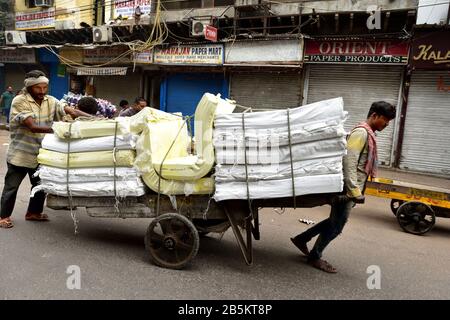 Old Delhi, India - 7th novembre 2019:Spostamento di un carretto a mano sovraccaricato sulla strada Foto Stock