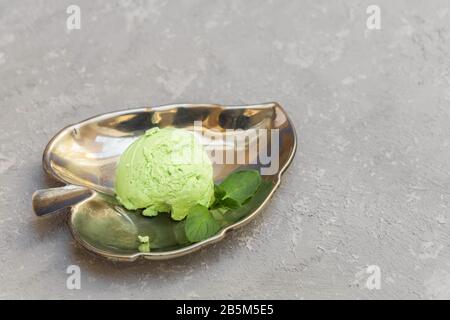 Facile e salutare gelato avocado fatto in casa con avocado, banana, foglie di menta su sfondo grigio neutro con spazio copia Foto Stock