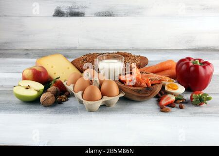 Concetto di allergia alimentare. Alimenti allergici come mandorle, latte, formaggio, fragola, pane, semi, uova, arachidi e crostacei o gamberetti Foto Stock