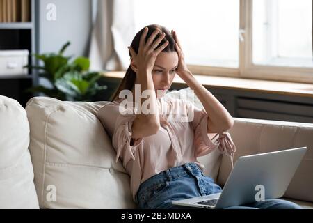 Nervosa frustrato giovane donna che guarda lo schermo del computer. Foto Stock