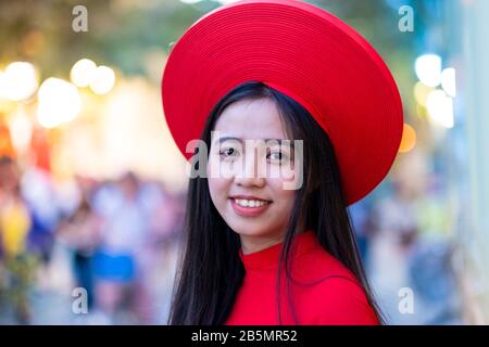 Una giovane donna vietnamita indossa un abito tradizionale rosso (Ao dai) Foto Stock