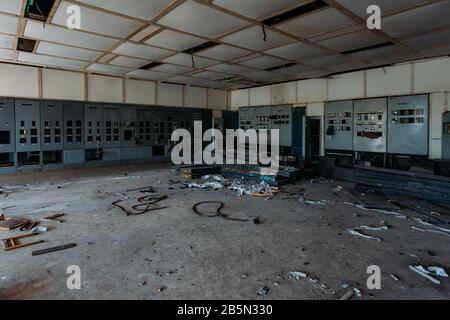 Armadi elettrici rotti con quadri di comando in fabbrica abbandonata. Foto Stock