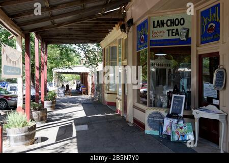 Marciapiede coperto con pubblicità di tè e caffè sulle vetrine dell'ex mulino Flour di Warnock costruito nel 1873, Maldon, Victoria, Australia. Mal Foto Stock