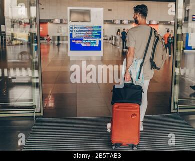 Uomo di viaggiare in aereo. Giovane passeggero in attesa all'aeroporto per un volo ritardato Foto Stock