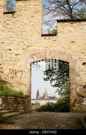 Cattedrale di San Vito, vista attraverso un cancello aperto del muro medievale di fame di pietra arenaria e mattoni, Kinsky Garden, Petřín Hill, praga Foto Stock